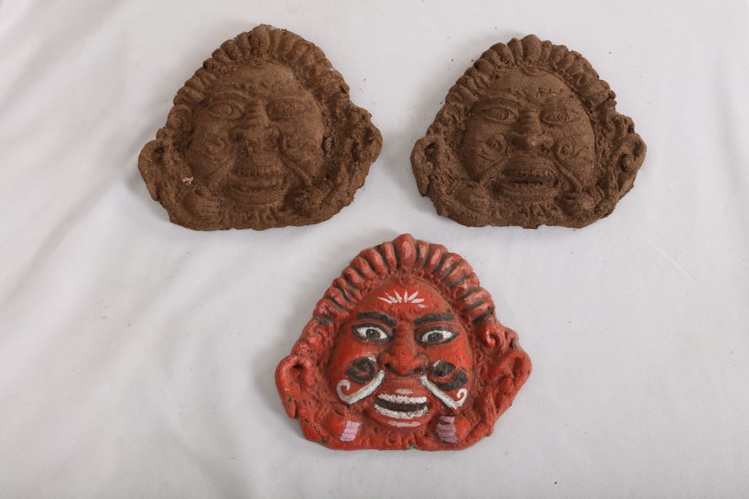 Hand-molded cow dung ceremonial face masks